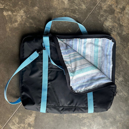 Black briefcase made with blue straps with corner folded down to show lining