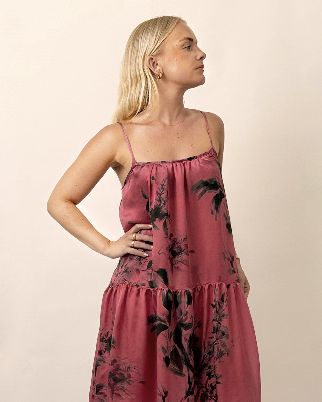 Woman wearing a pink floral dress against a beige background
