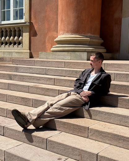 Man sitting on stone steps in front of a classical building