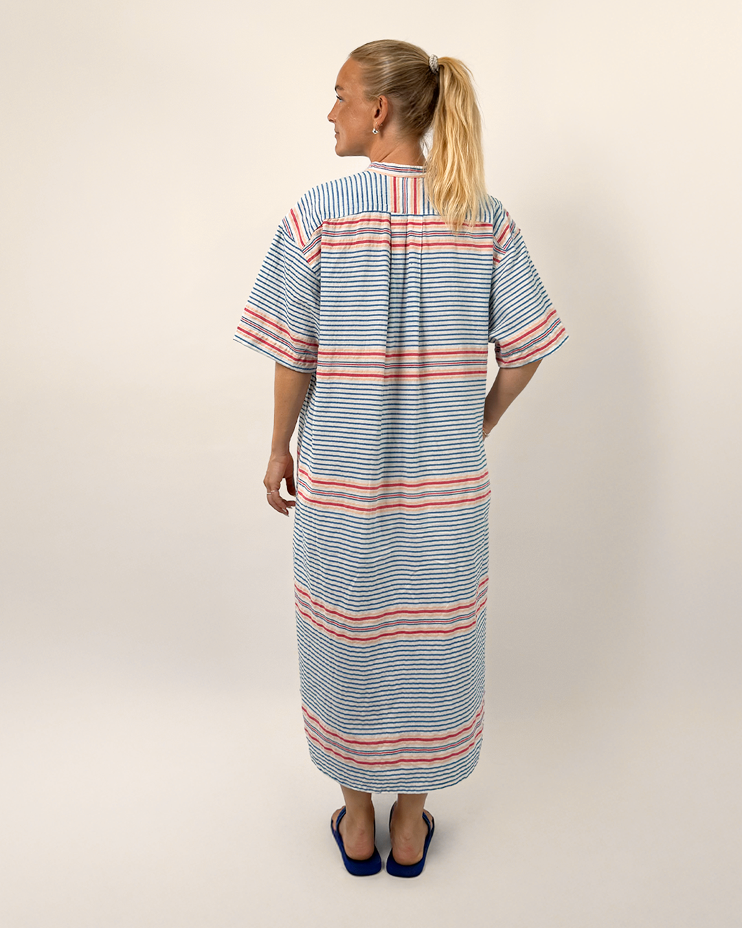 Woman wearing a striped dress with a plain background