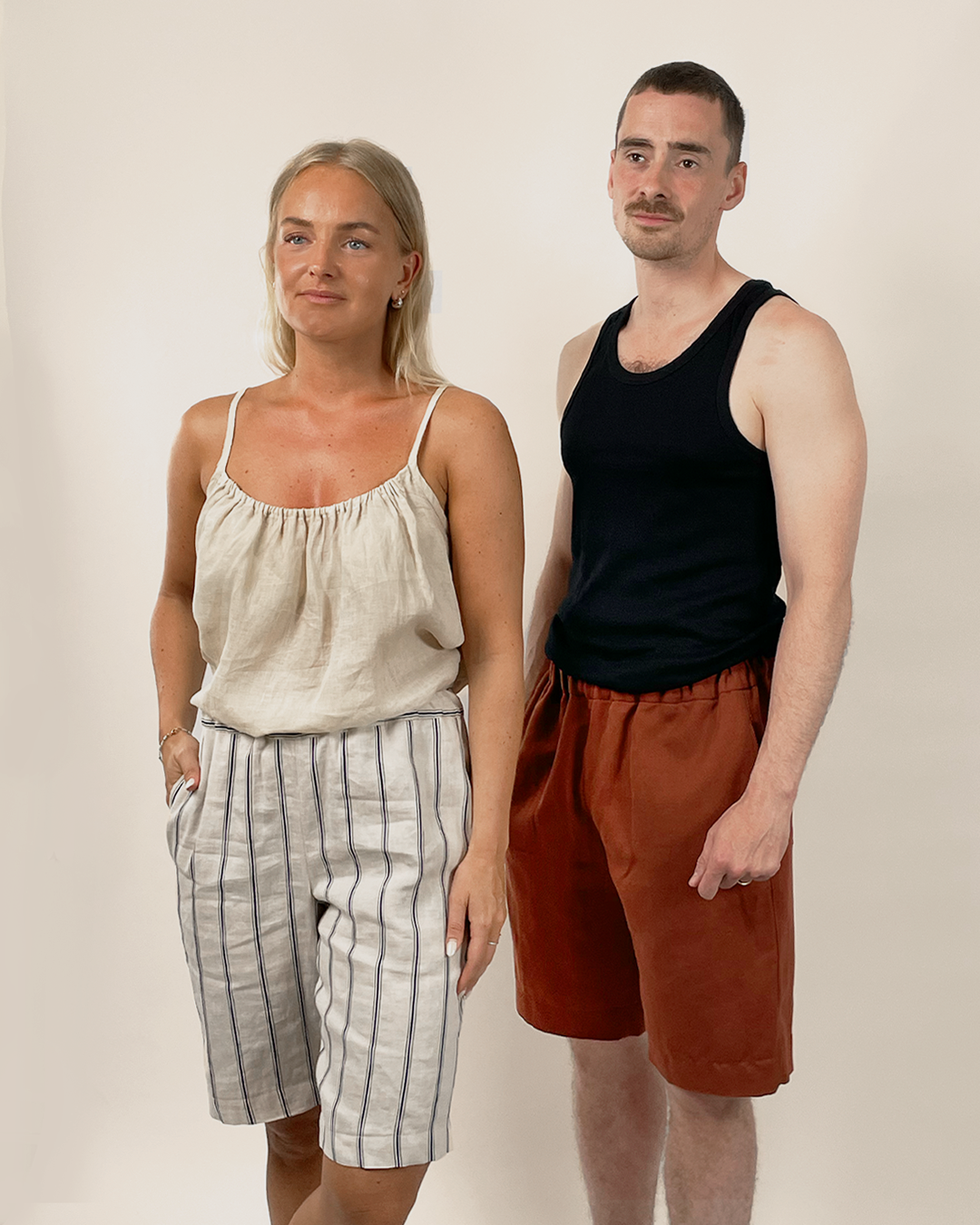 Two people standing side by side against a plain background