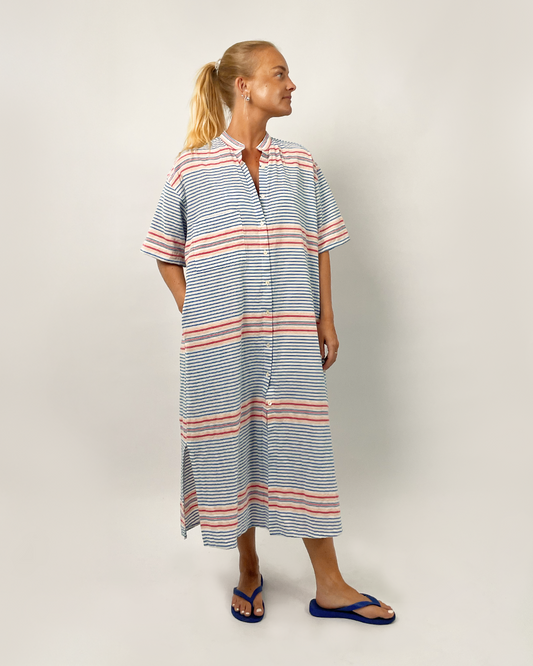 Woman wearing a striped dress on a plain background