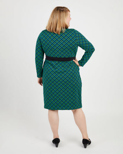 Woman wearing a green patterned dress on a white background. This dress is the Appleton Wrap Dress sewing pattern from Cashmerette.