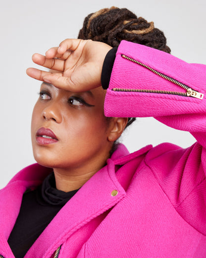 Person wearing a bright pink jacket with a white background. This biker jacket is the Canton Moto Jacket sewing pattern from Cashmerette.
