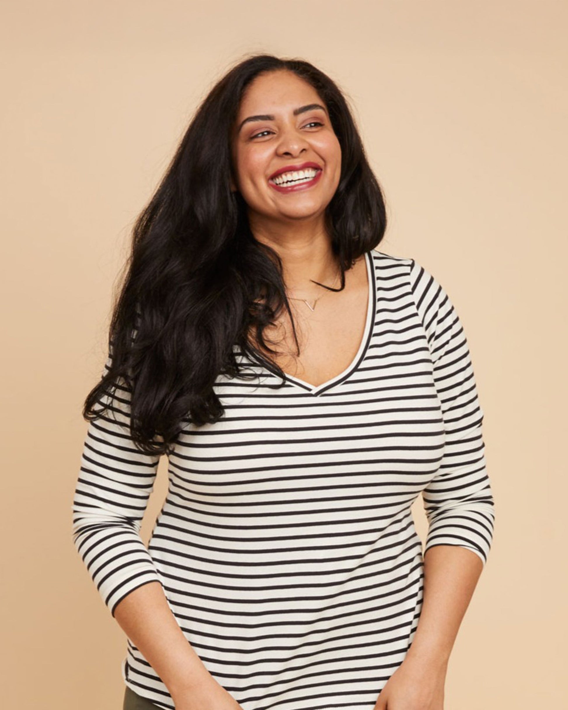 Woman wearing a black and white striped shirt against a beige backgroundThis t-shirt is the Concord T-Shirt sewing pattern from Cashmerette.