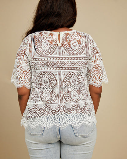 White lace top worn by a person on a beige background. This top is the Montrose Top sewing pattern from Cashmerette.
