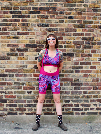 Rouleur Leggings view B - image of woman in brightly coloured bib shorts standing against a brick wall