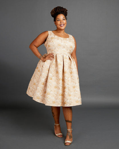 Woman wearing a beige floral dress against a gray background. This dress is the Upton Dress & Skirt sewing pattern from Cashmerette.